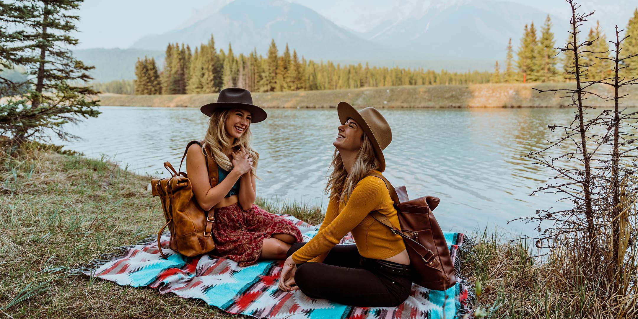 Piknik am See mit Lederrucksaecken und zwei Frauen Landscape