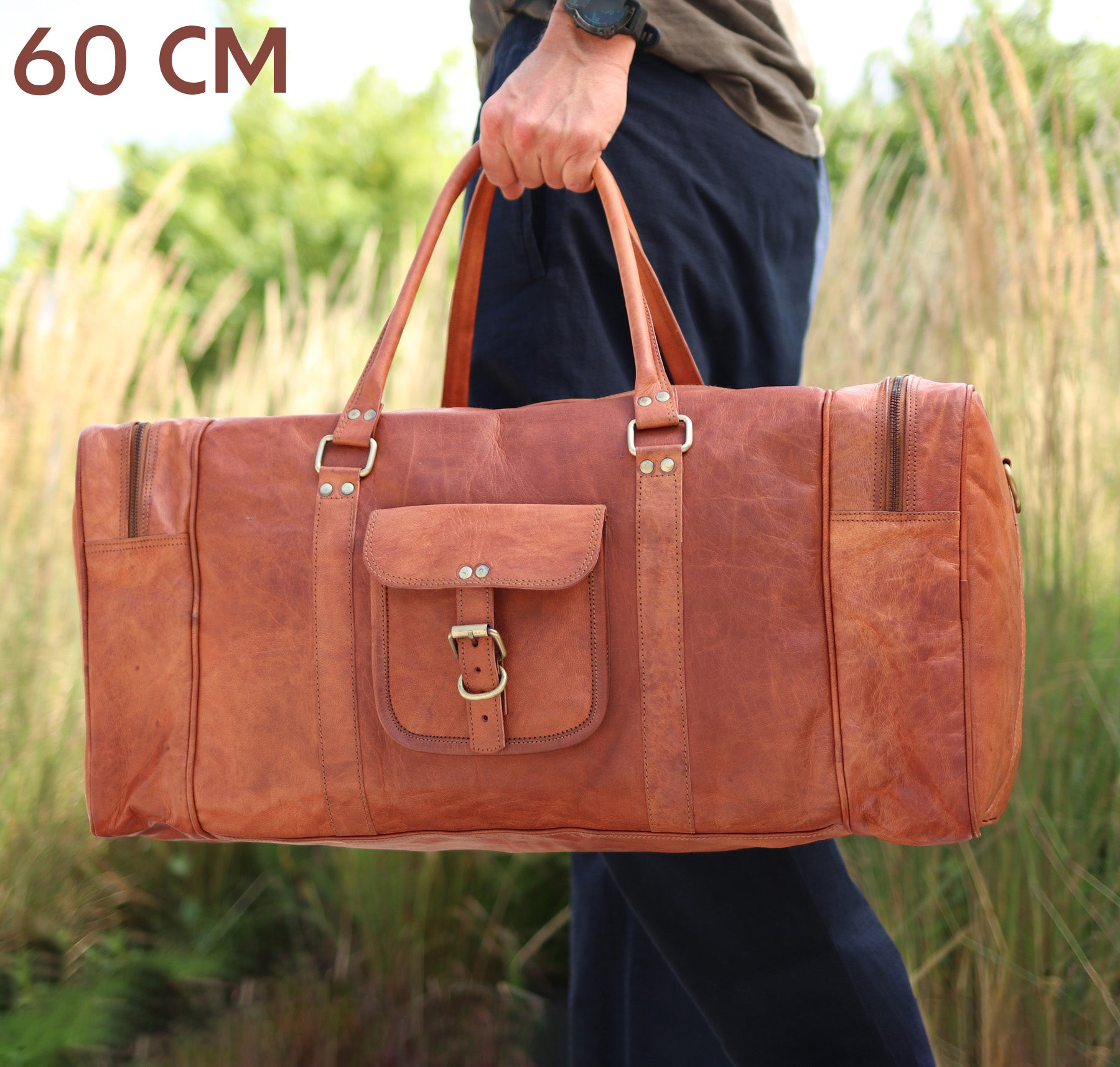 Reisetasche Ziegenleder in Kastanien braun Mann traegt ein dunkelgruenes T-Shirt mit einer blauen Hose